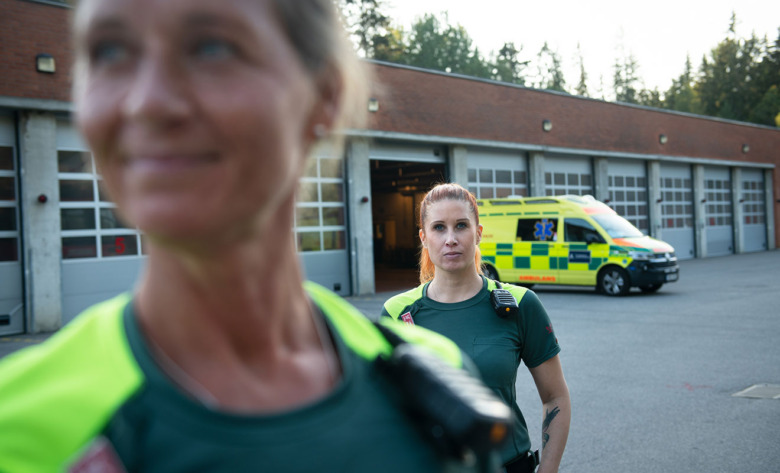 Åsa Jonsson, ambulanssjukvårdare, och Linda Orrvik, ambulanssjuksköterska, framför ambulansen. Foto: Anders G Warne
