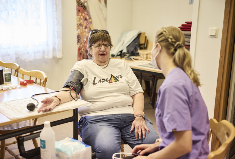 Sjuksköterskan Evelina Markström kollar blodtrycket på patient Ann-Sofi Nordvall. De sitter mitt emot varandra och pratar.