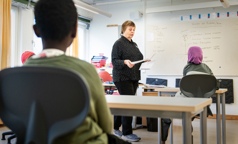 Kerstin Aronsson, skolsköterska, delar ut papper i ett klassrum på Rinkebyskolan. Foto: Anders G Warne.