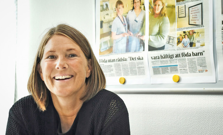 Anna Uhlin, barnmorska, i sitt arbetsrum framför en artikel om det projekt hon leder för att skapa lugn vid förlossningar med hjälp av ljud och ljus.