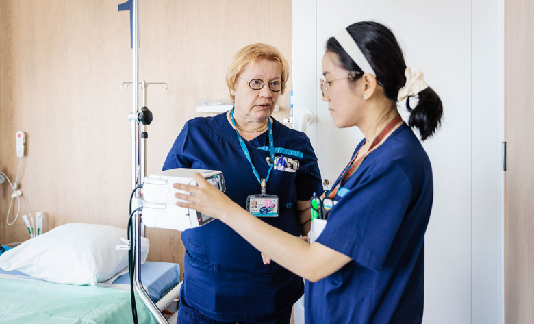 Sjuksköterskorna Leena Alppi och Jenifer Zabala övar arbetsmoment med infusionspumpar på Cancercentrum i Helsingfors.  Till artikel om magnetsjukhus.