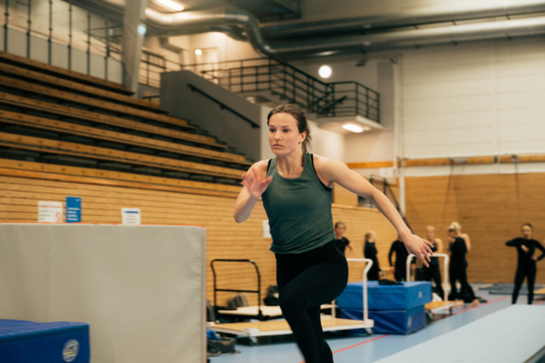 Elitgymnasten och sjuksköterskan Agnes Arvidsson springer i gympahallen.