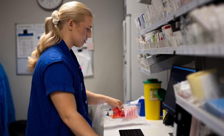 Sjuksköterskan Emma Hall sedd i profil i läkemedelsförrådet på sjukhuset där hon arbetar. 