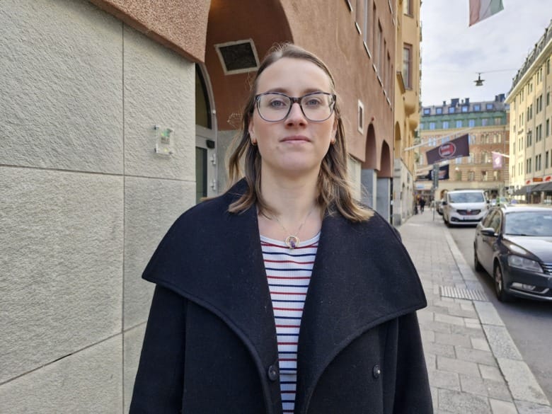 Porträtt på Amanda Svorén, biomedicinsk analytiker, står på gatan framför en husfasad.