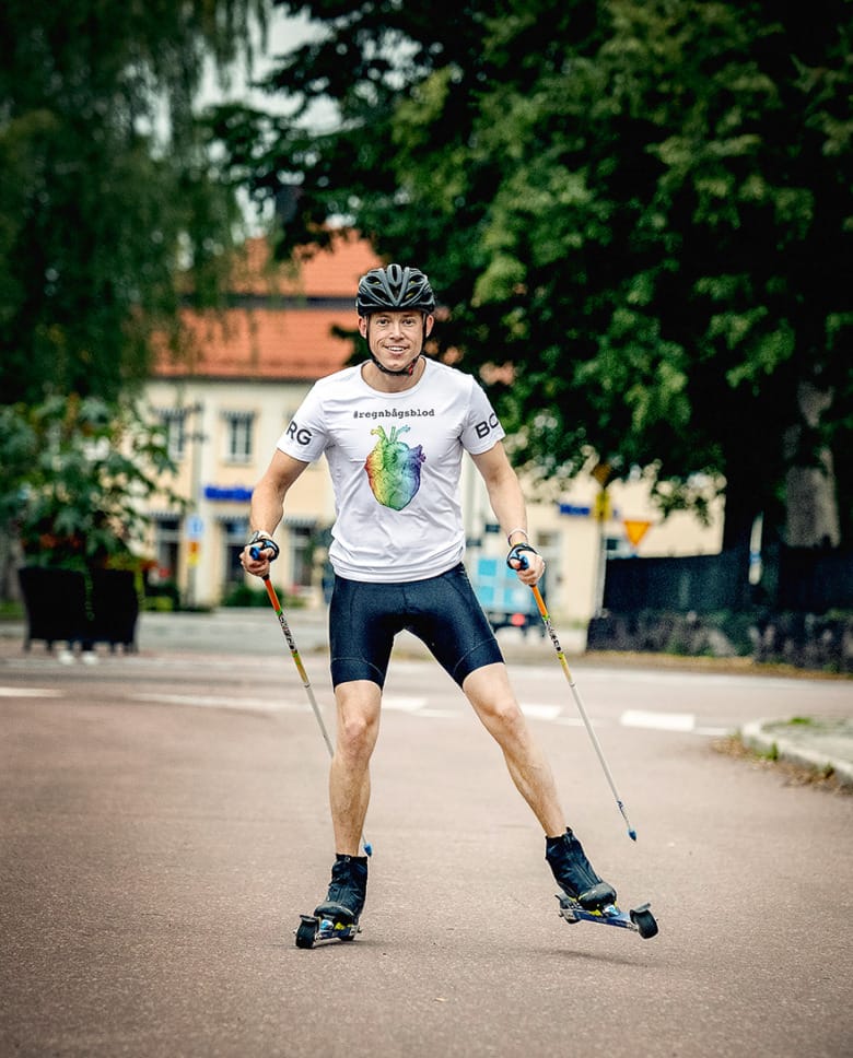Sjuksköterskan Tobias Ström åker rullskidor på en bilväg och tittar rakt in i kameran. Han är iklädd träningskläder och hjälm. På hans t-shirt syns ett regnbågsfärgat anatomiskt hjärta och hashtagen regnbågsblod.