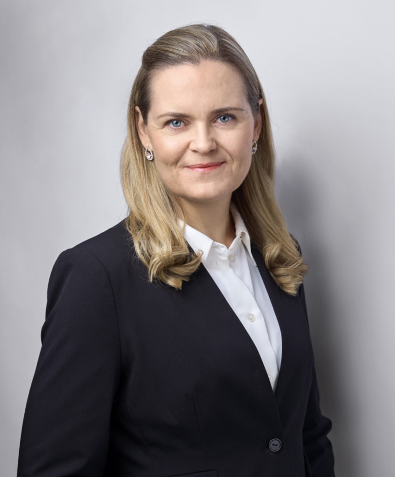 Porträtt på Sarah Sim, standardiseringschef på SiS. Hon har blont hår, en vit skjorta och en svart kavaj.