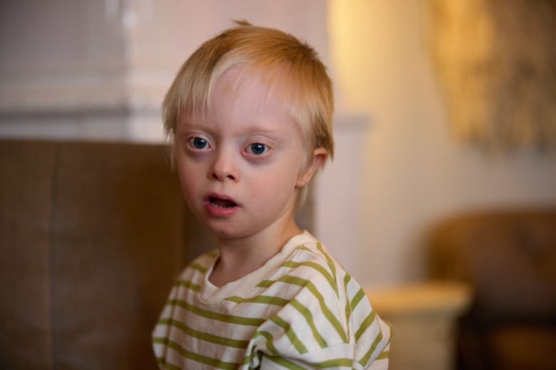 Porträtt på Vide, 6 år, som till skädespelaren Sanna Sundqvist. Vide föddes med Downs syndrom. På bilden har han en vit- och grönrandig tröja på sig.