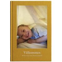 Bokomslag till boken Välkommen- att få ett barn med Downs syndrom. Omslaget är gult med ett foto på ett barn med Downs syndrom. Foto Emilia Bergmark Jimenez.