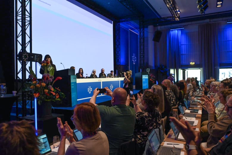 Kongressen applåderar och filmar när nyvalda ordföranden Sophia Godau står i talarstolen.