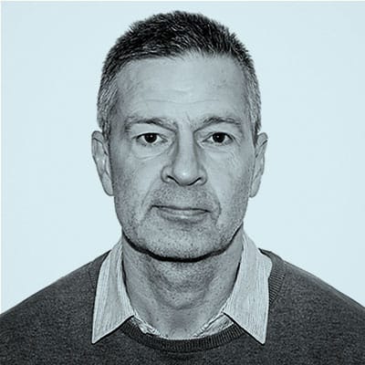 Porträtt av Jonas Wrigstad. Han bär skjorta, tröja och tittar in i kameran.