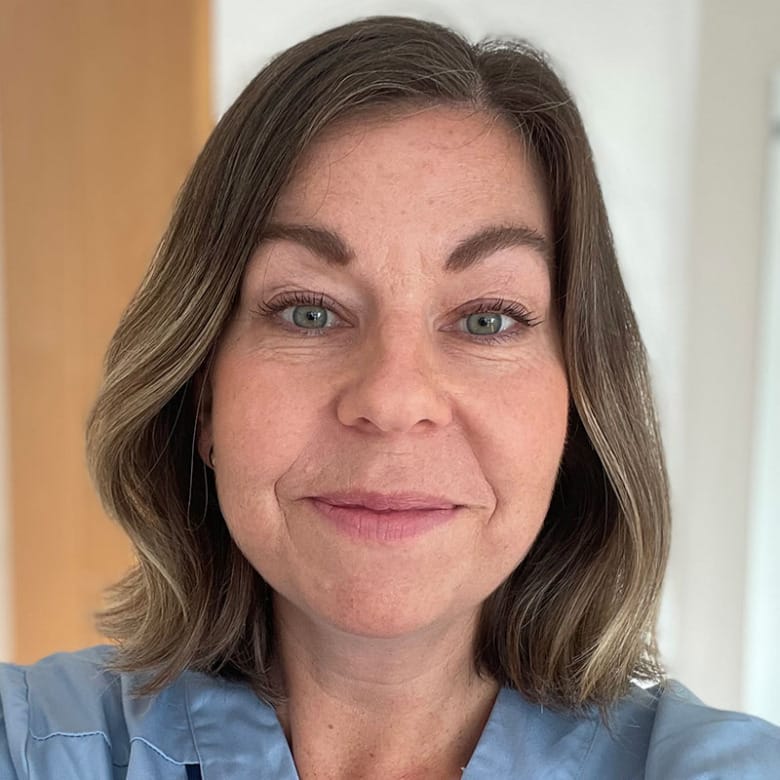 Porträtt av Rebecca Odhagen. Hon har mörkblont hår i page och blå bussarong.